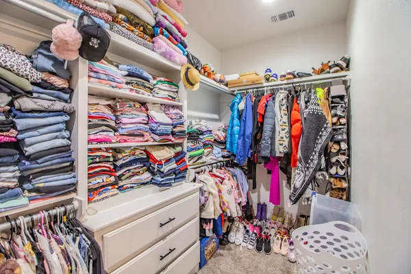 a view of walk in closet with clothes