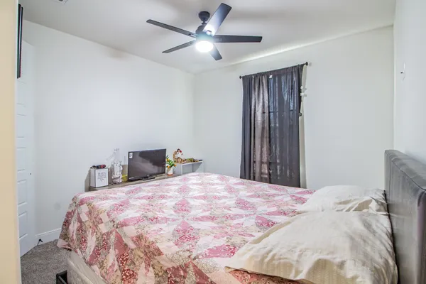 a bedroom with a large bed and a chandelier