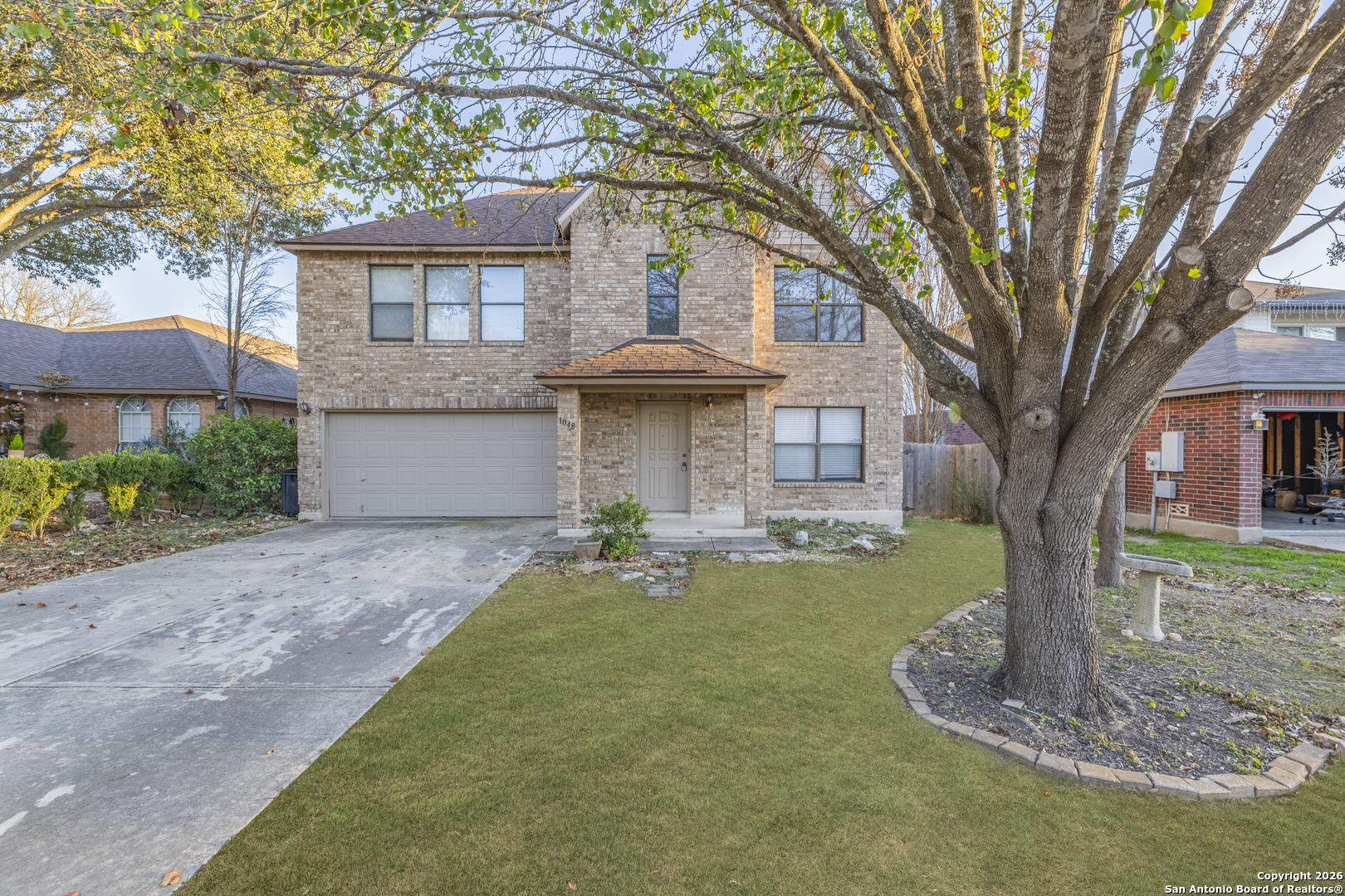 a front view of a house with a garden and trees