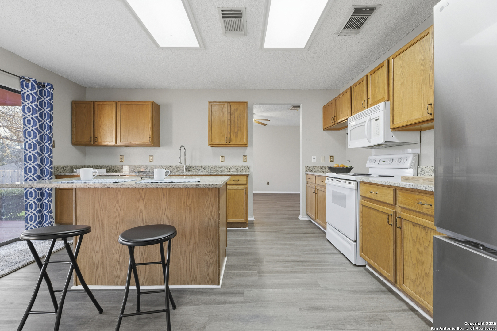 1048 Sycamore Schertz, TX 78154 - Photo 11 of 31 a kitchen with stainless steel appliances granite countertop a table chairs sink and cabinets