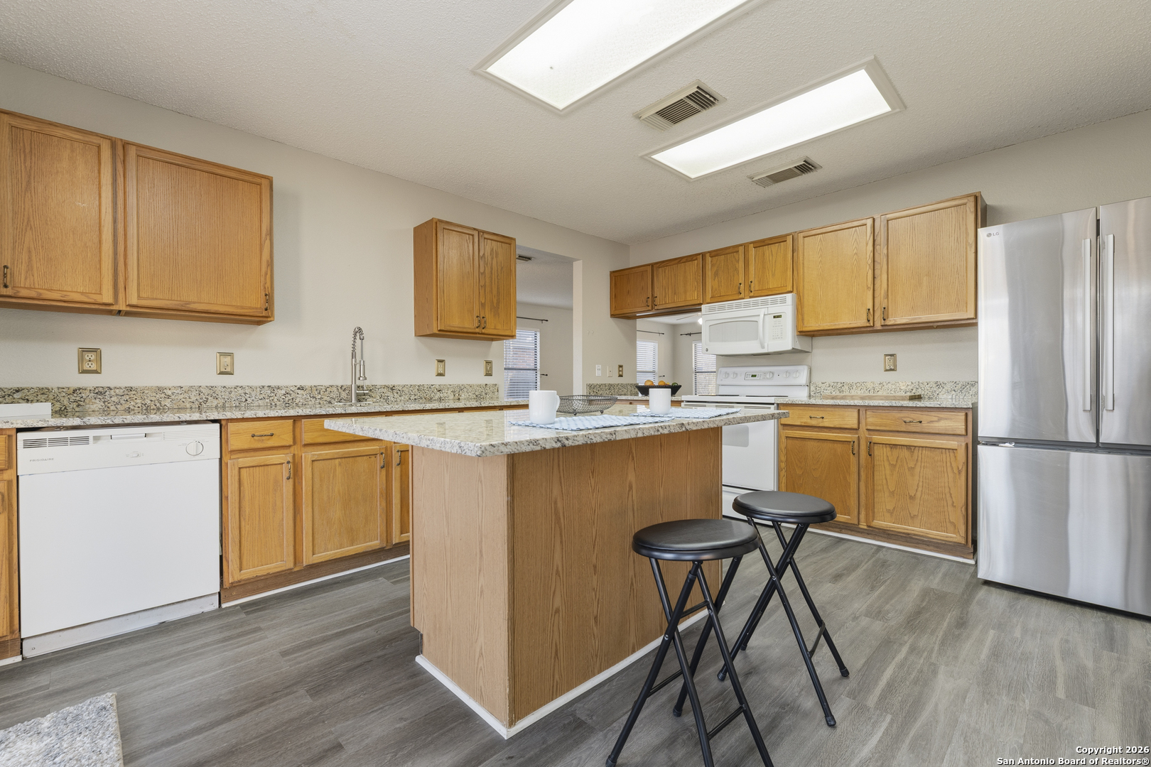 1048 Sycamore Schertz, TX 78154 - Photo 12 of 31 a kitchen with a refrigerator a sink and cabinets