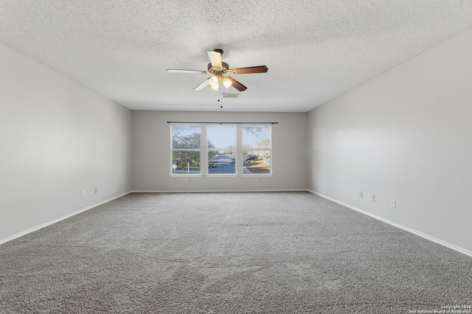 1048 Sycamore Schertz, TX 78154 - Photo 21 of 31 an empty room with windows and chandelier fan