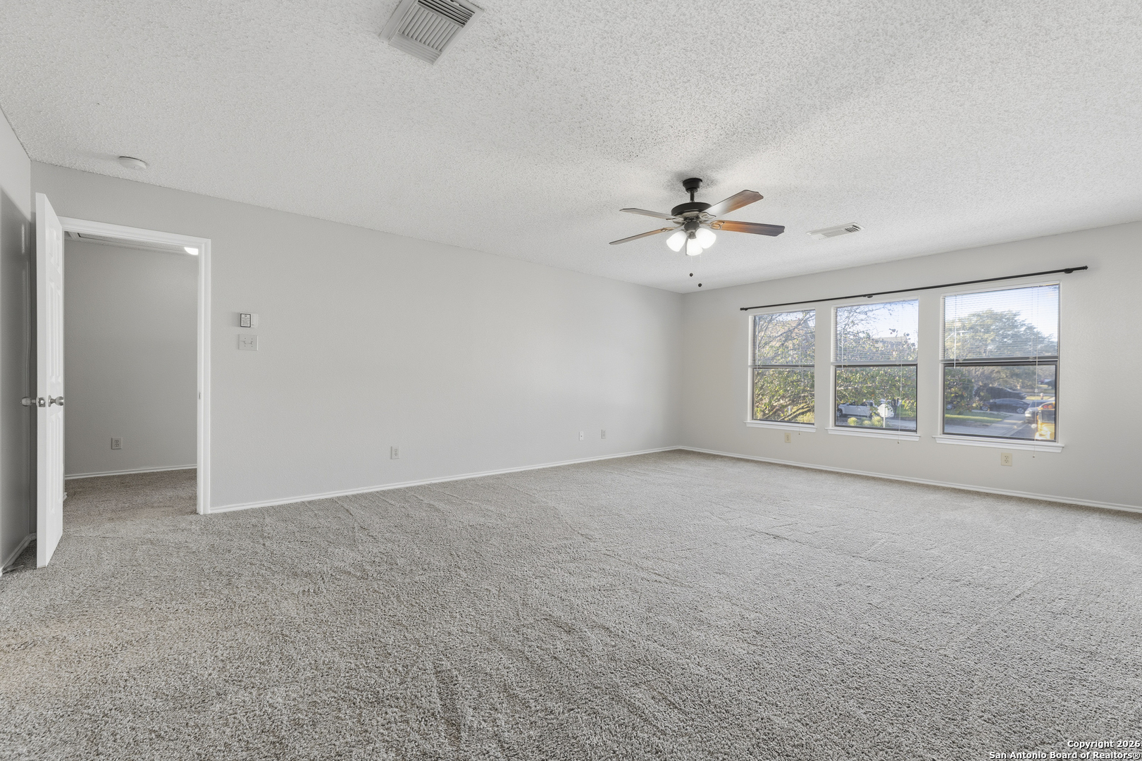1048 Sycamore Schertz, TX 78154 - Photo 22 of 31 an empty room with chandelier fan and windows
