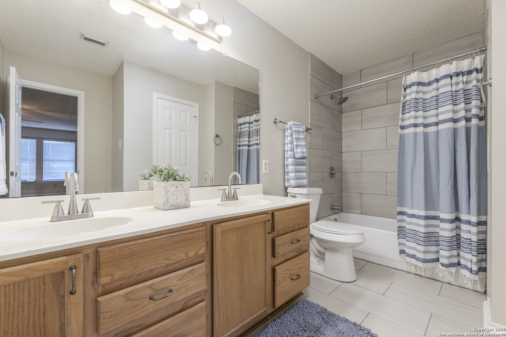 1048 Sycamore Schertz, TX 78154 - Photo 24 of 31 a bathroom with a double vanity sink toilet and shower