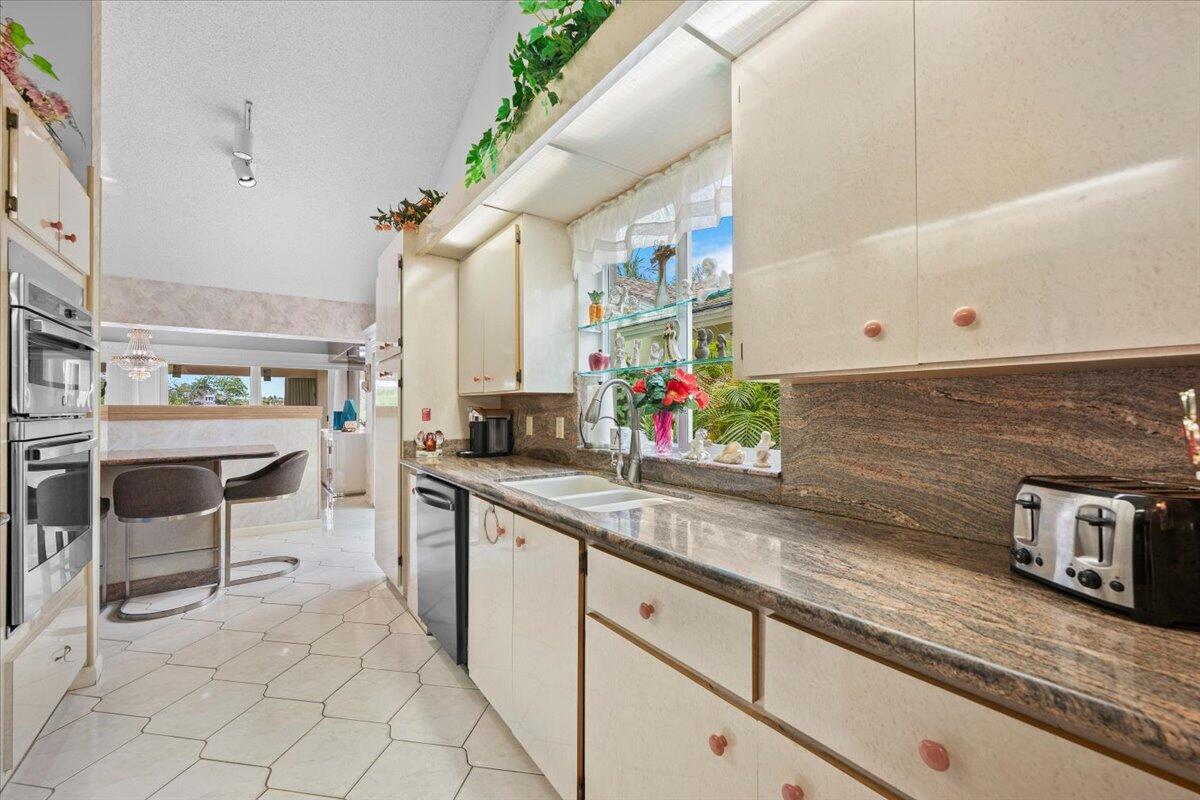 352 River Edge Road Jupiter, FL 33477 - Photo 9 of 56 a kitchen with stainless steel appliances granite countertop a sink and cabinets