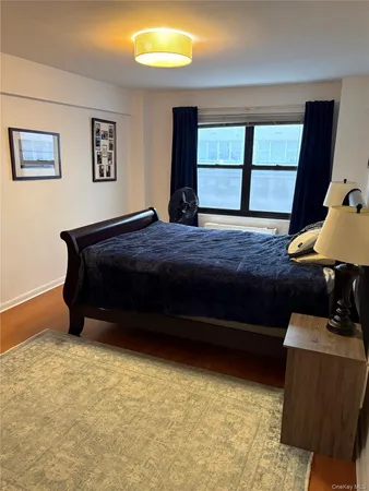 a spacious bedroom with a bed and wooden floor