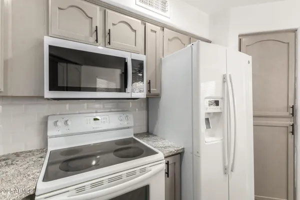 a kitchen with granite countertop white cabinets and a sink