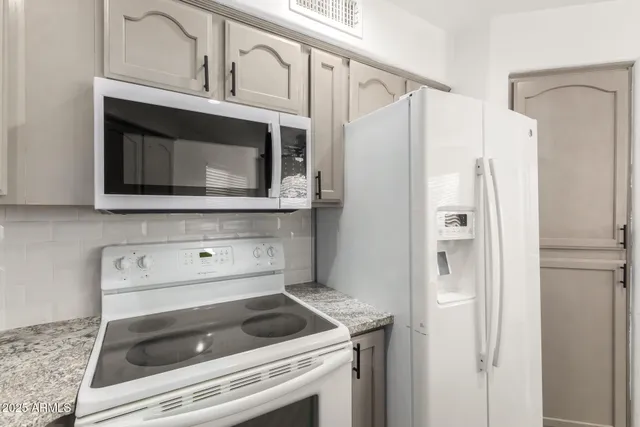 a kitchen with granite countertop white cabinets and a sink