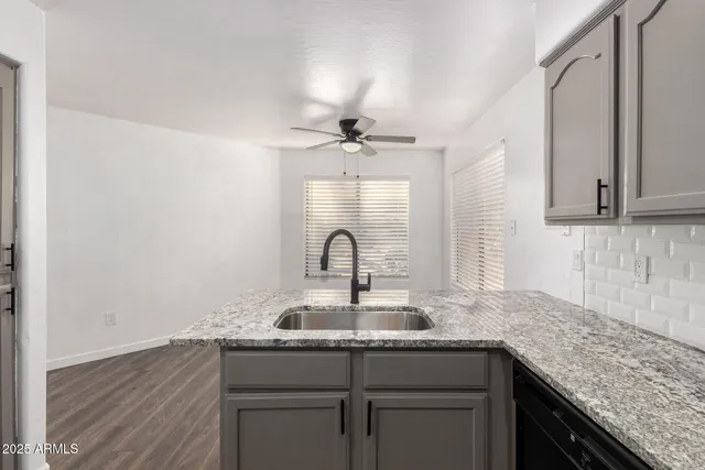 an empty room with wooden floor and ceiling fan