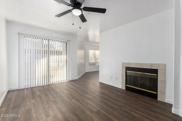 a view of empty room with wooden floor and ceiling fan
