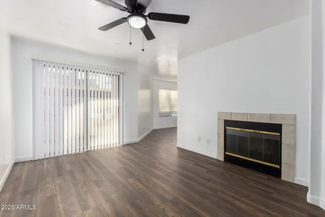 a view of empty room with wooden floor and ceiling fan