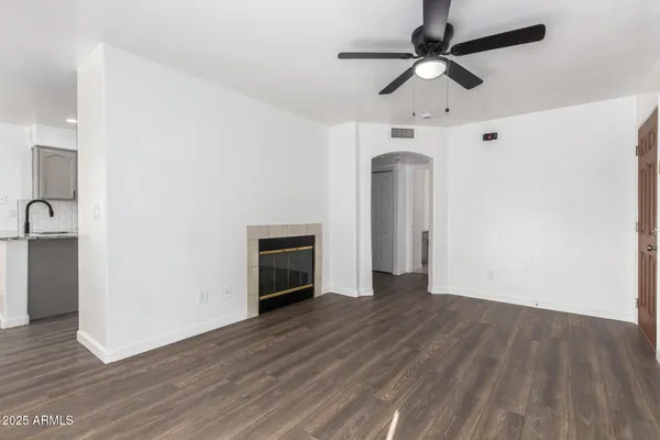 a hallway with wooden floor a fireplace and a way to kitchen