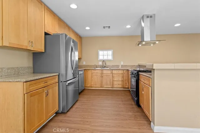 a kitchen with stainless steel appliances a refrigerator sink and cabinets