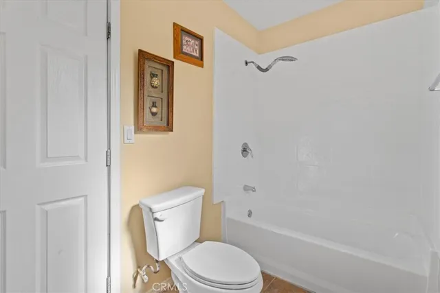 a white toilet sitting next to a bath tub