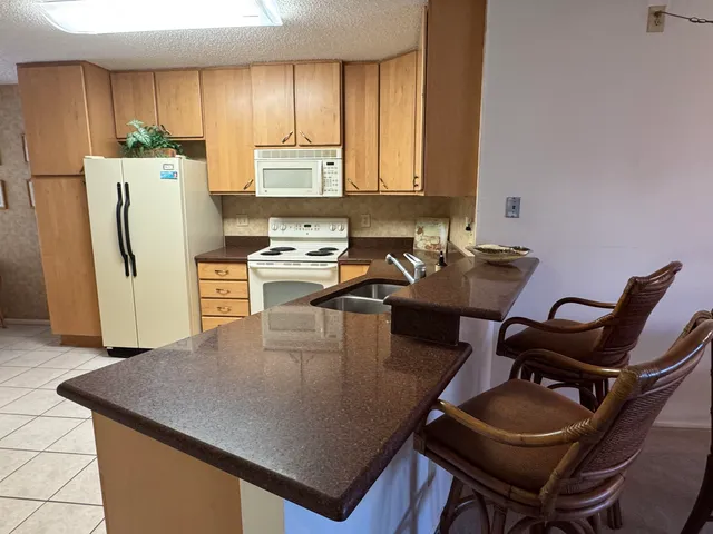 a kitchen with a table chairs and refrigerator