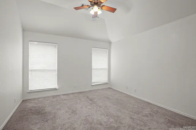 an empty room with windows and fan