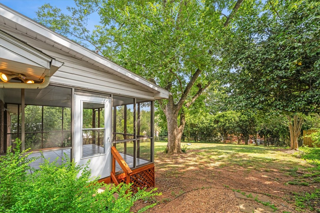 16 State Rd S-23-429 Greenville, SC 29609 - Photo 29 of 34 Mature trees shade a spacious lawn adjacent to the screen-enclosed porch.