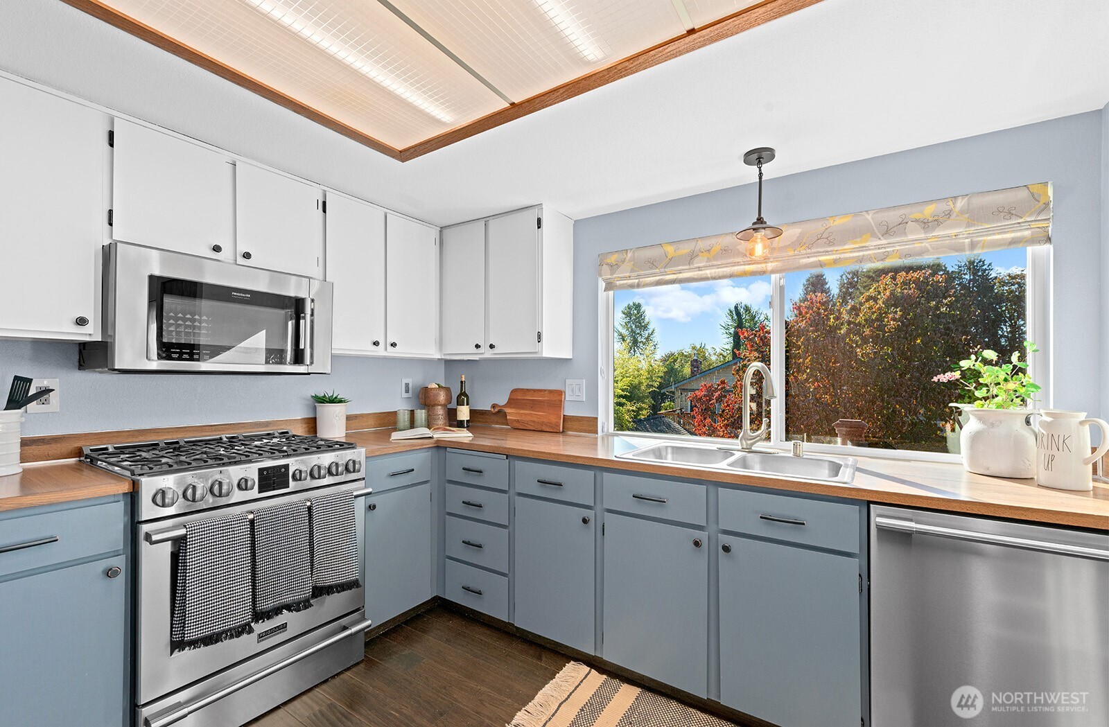 2604 177th Street Southeast Bothell, WA 98012 - Photo 9 of 35 a kitchen with white cabinets a sink a stove and a window