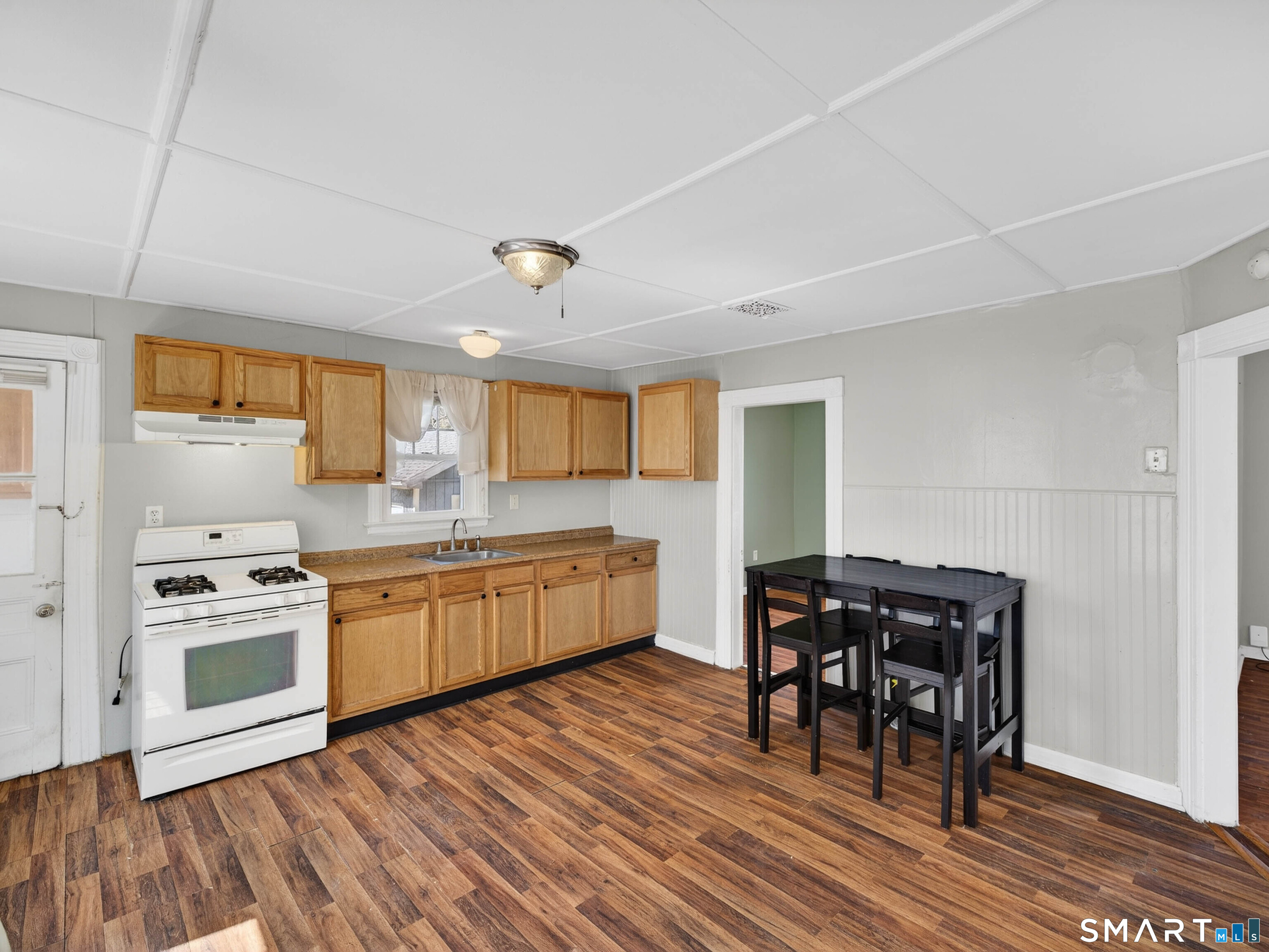 82 North Street Norwich, CT 06360 - Photo 8 of 38 a kitchen with stainless steel appliances granite countertop a stove a refrigerator a sink dishwasher with a dining table and chairs