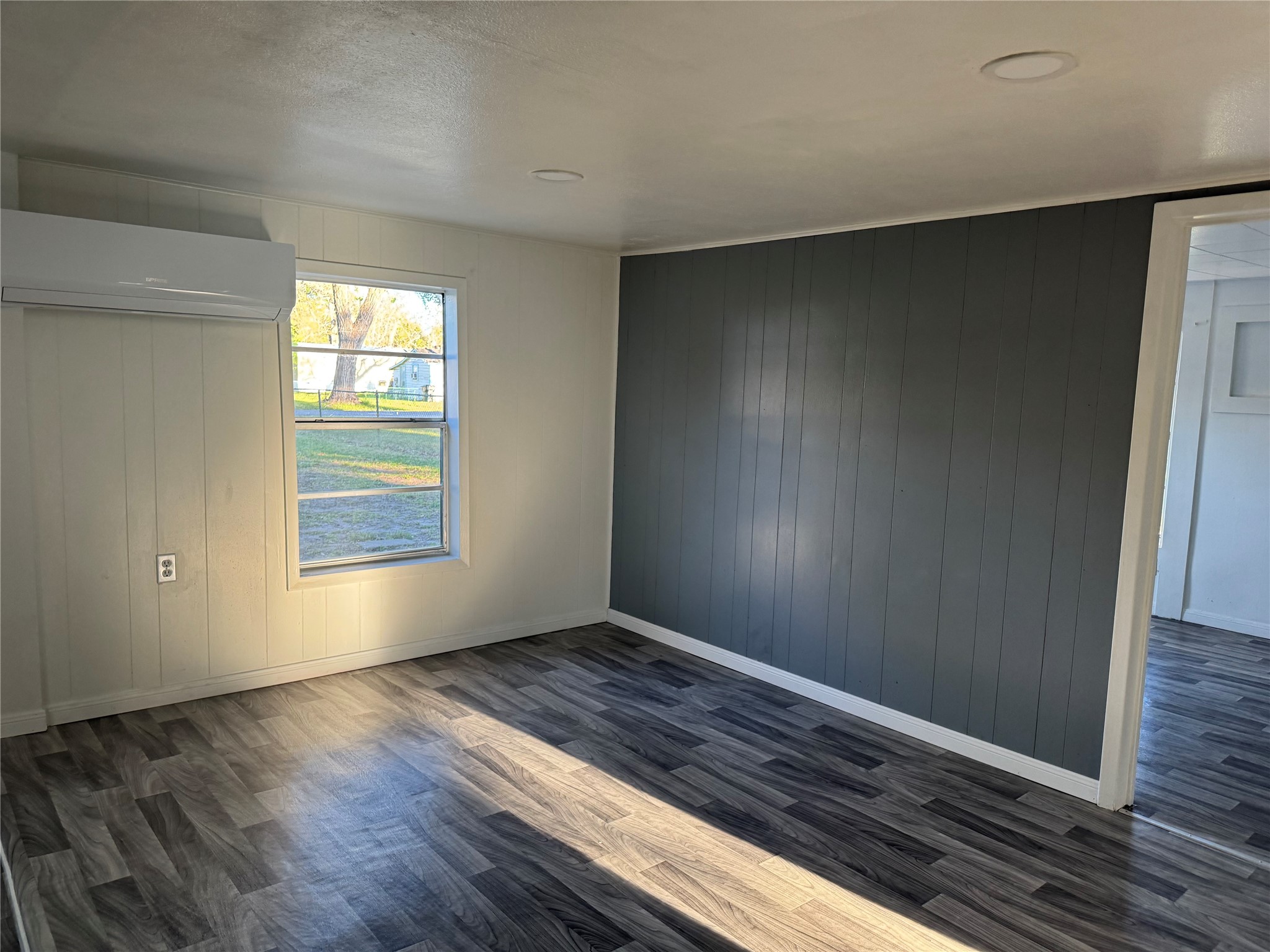 406 7th Street Alvin, TX 77511 - Photo 5 of 14 a view of an empty room with wooden floor and a window