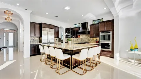 a large kitchen with kitchen island a large counter space a sink appliances and cabinets