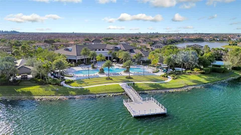 an aerial view of a house with a yard and lake view
