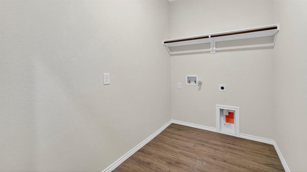 4008 Ripplewood Drive Lindale, TX 75771 - Photo 26 of 37 Dedicated laundry area featuring wood-finish flooring, light neutral wall tones, and a built-in shelf with hanging rod