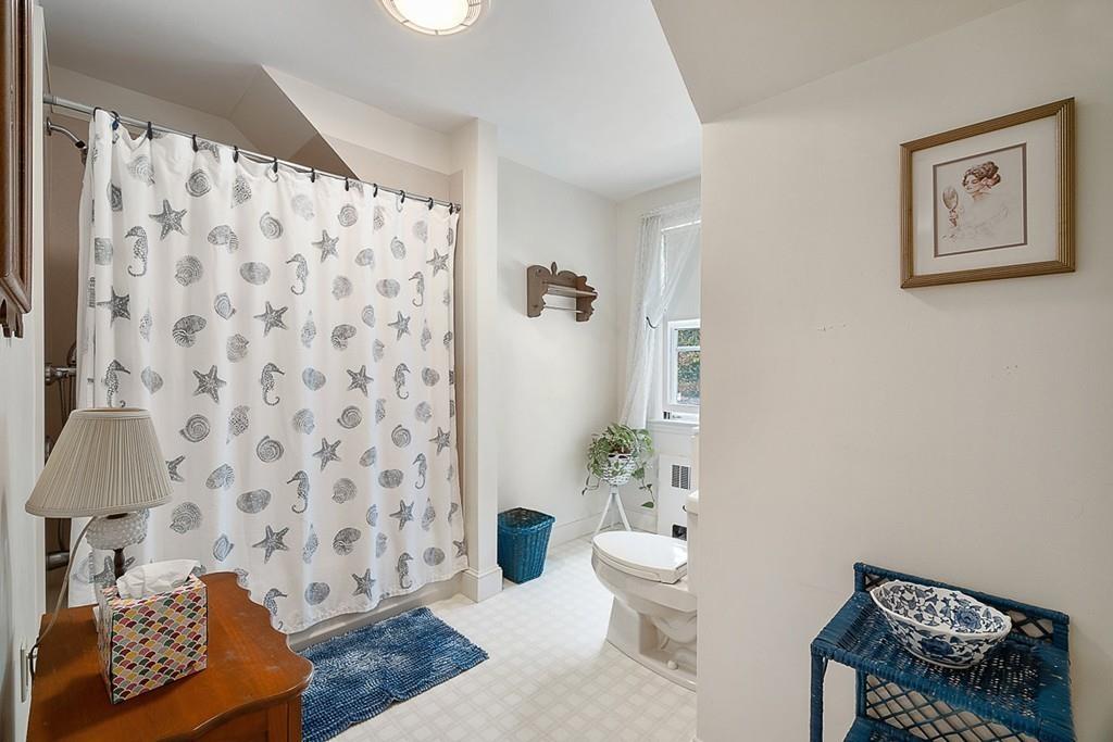 79 Pleasant Street Manchester, MA 01944 - Photo 23 of 28 a bathroom with a toilet and a shower curtain