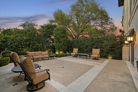 a view of a patio with table and chairs potted plants and a large tree