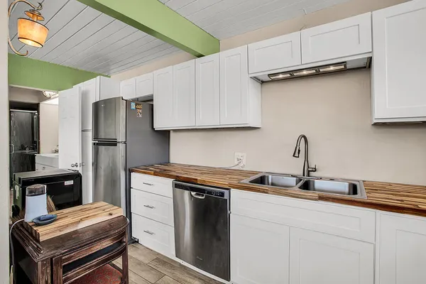 a kitchen with stainless steel appliances granite countertop a sink and a refrigerator