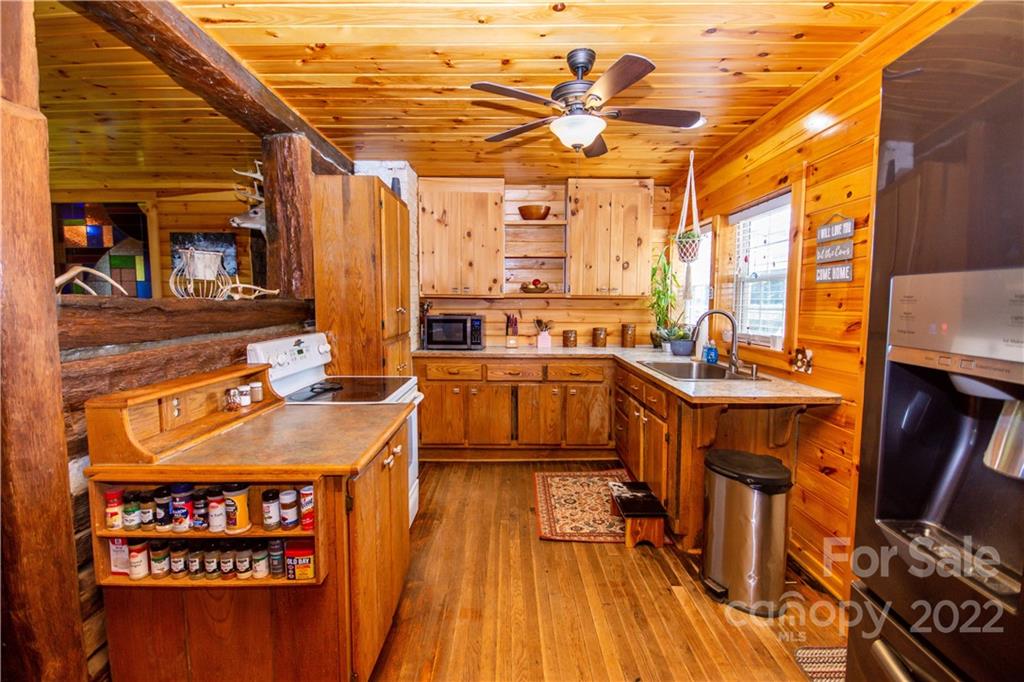 161 Eagle Mills Road Harmony, NC 28634 - Photo 13 of 42 a view of a kitchen with stainless steel appliances granite countertop a stove and a dining table