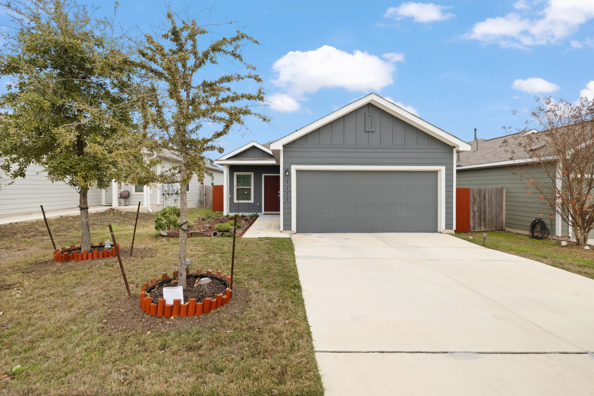 Ranch-style home featuring board and batten siding, driveway, and a garage