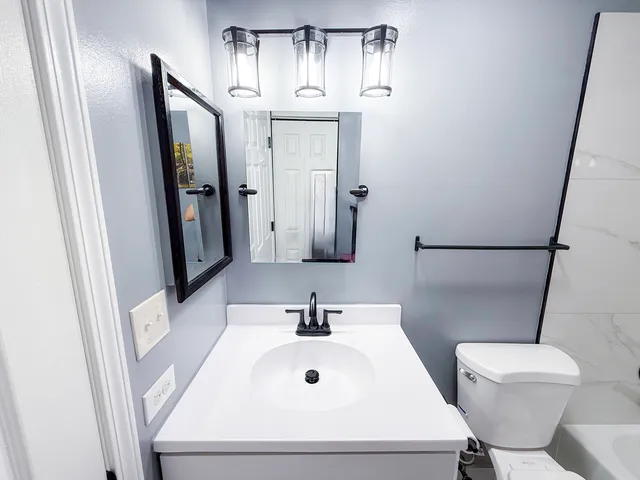 a bathroom with a sink a toilet and mirror