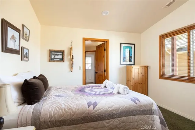 a bedroom with a bed and painting on the wall