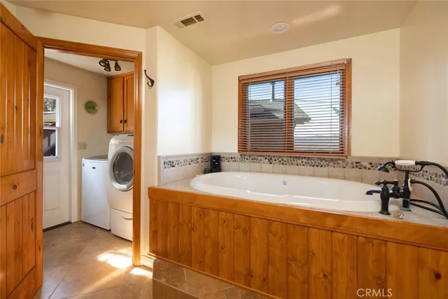 a bathroom with a tub a sink and a window