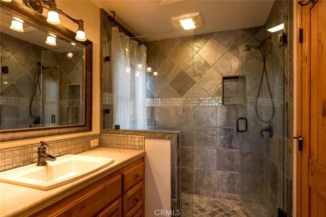 a bathroom with a sink shower and a mirror