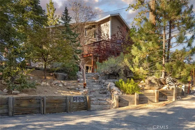 a front view of a house with a tree