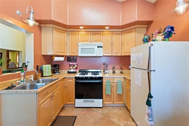 a kitchen with a refrigerator a stove a sink dishwasher and a oven with wooden floor