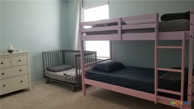 a bedroom with a bunk bed and a window