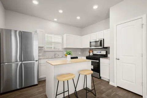 a kitchen with stainless steel appliances a refrigerator and a stove top oven