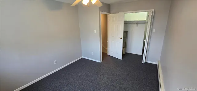 an empty room with a chandelier fan and a window