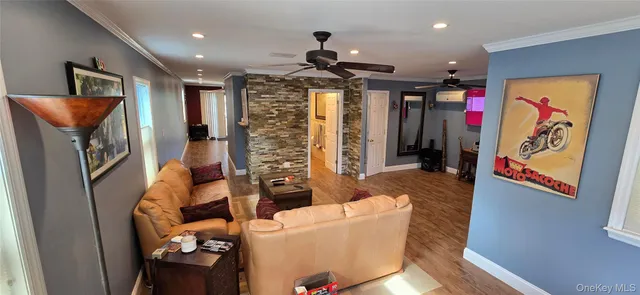 a living room with furniture and a ceiling fan