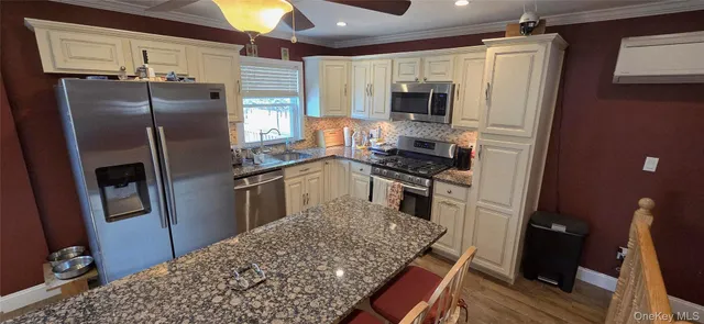 a kitchen with stainless steel appliances granite countertop a refrigerator stove and microwave