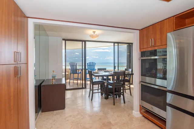 a dining room with furniture water view and a floor to ceiling window