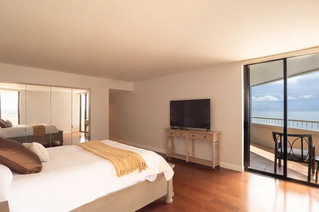 a bedroom with a bed and a flat tv screen on the dresser