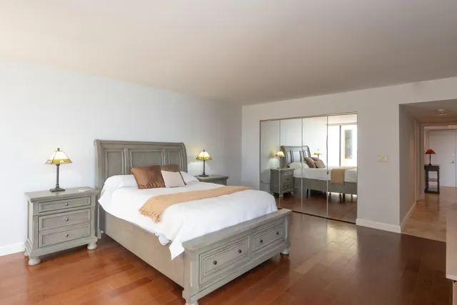 a bedroom with a bed and wooden floor