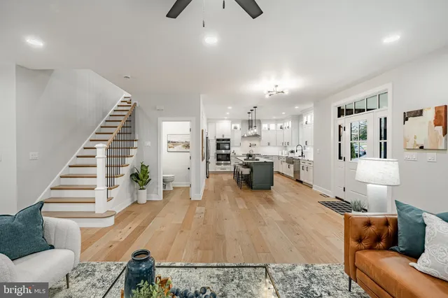 a living room with furniture and kitchen view with wooden floor