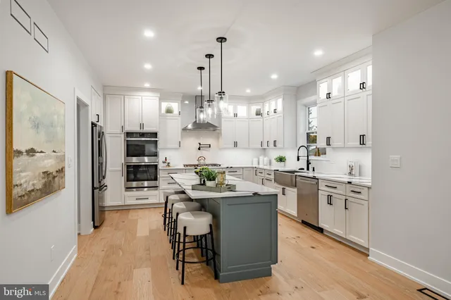 a kitchen with stainless steel appliances kitchen island granite countertop a sink and refrigerator