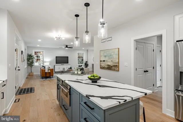 a kitchen with stainless steel appliances granite countertop a sink a stove and a wooden floor