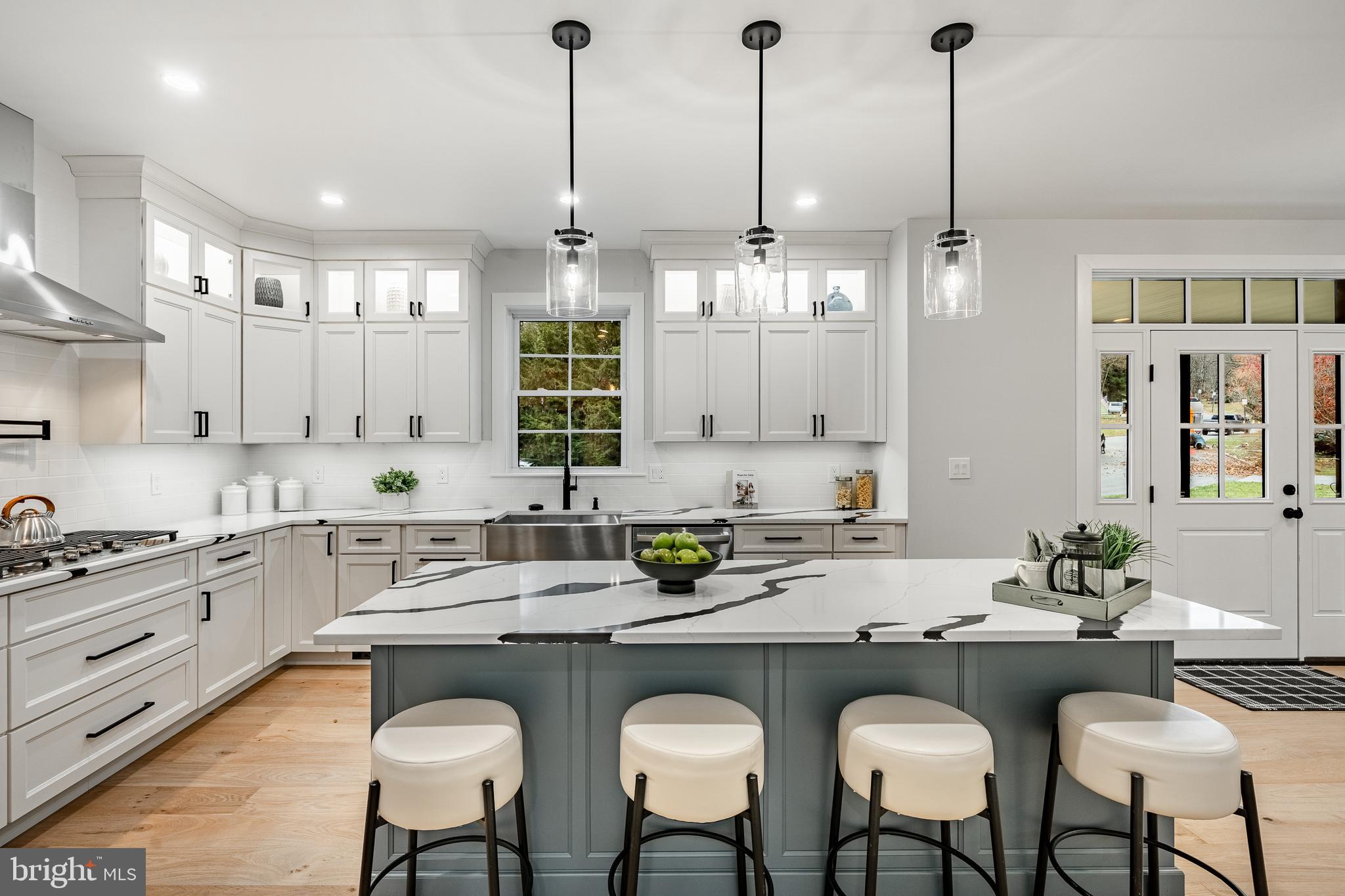 714 South Wayne Street West Chester, PA 19382 - Photo 19 of 62 a kitchen with stainless steel appliances granite countertop a sink a stove a dining table and chairs with wooden floor